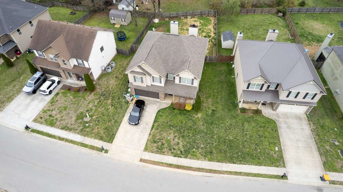 Aerial neighborhood view showing the home's desirable position in the Sunset Meadows community, with well-maintained neighboring properties, lush green lawns, and a welcoming streetscape.