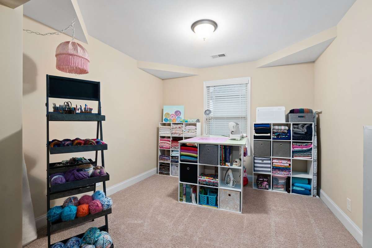 Private sitting nook off the primary suite, offering a quiet retreat space with carpet and natural light, perfect as a reading room, home office, or additional walk-in closet area.