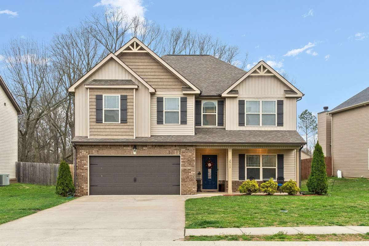 Stunning front exterior showcasing the home's craftsman-style curb appeal with stone and siding facade, 2-car garage, manicured landscaping, and charming architectural details.