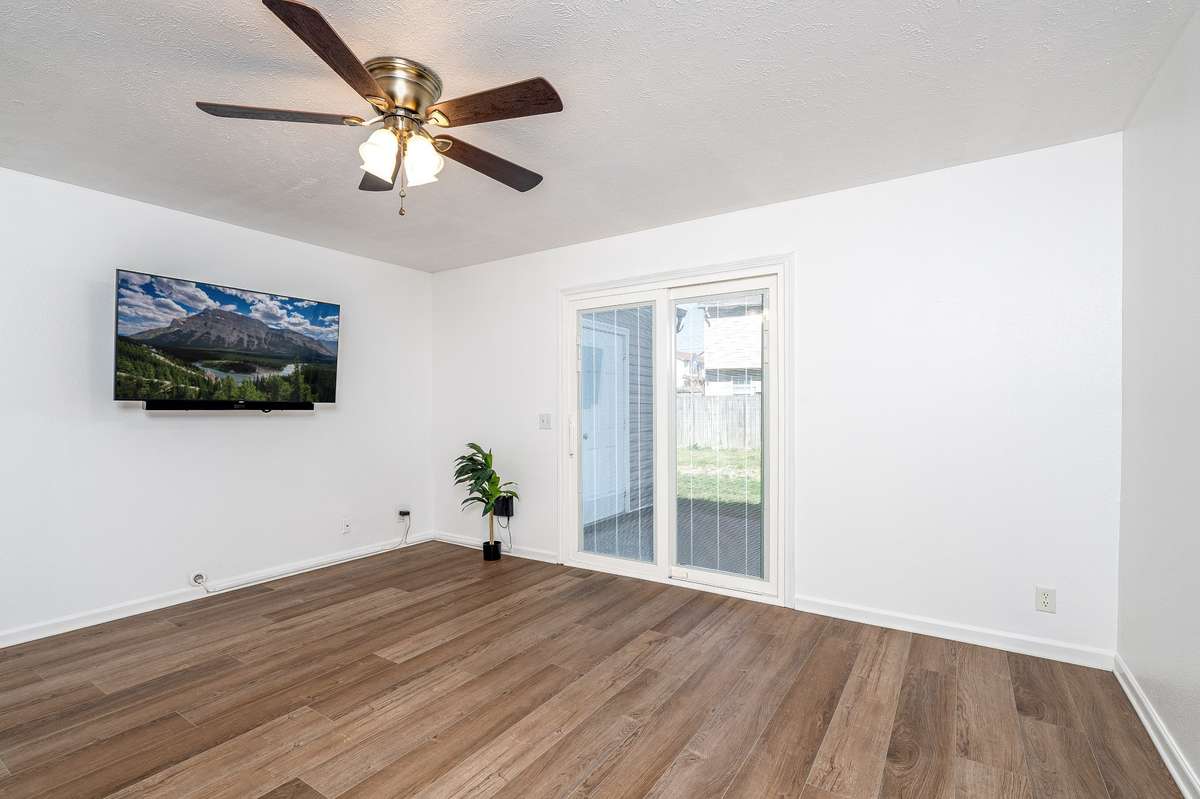 Spacious Living Room with updated sliding glass door & ceiling fan