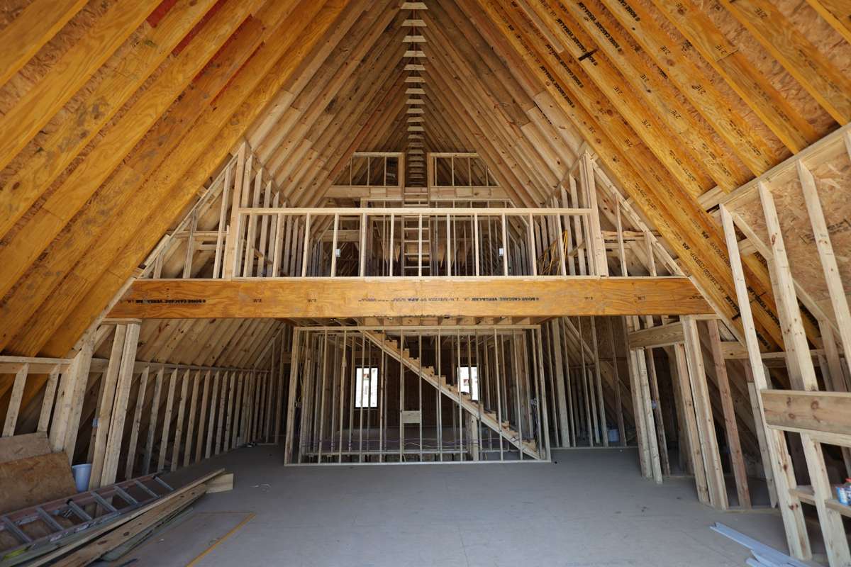 The center wall will feature 16 feet of custom cabinetry with a custom range hood centered between them, along with a large 10-foot island. To the left, there will be additional custom cabinetry and a custom arched coffee/wine bar.