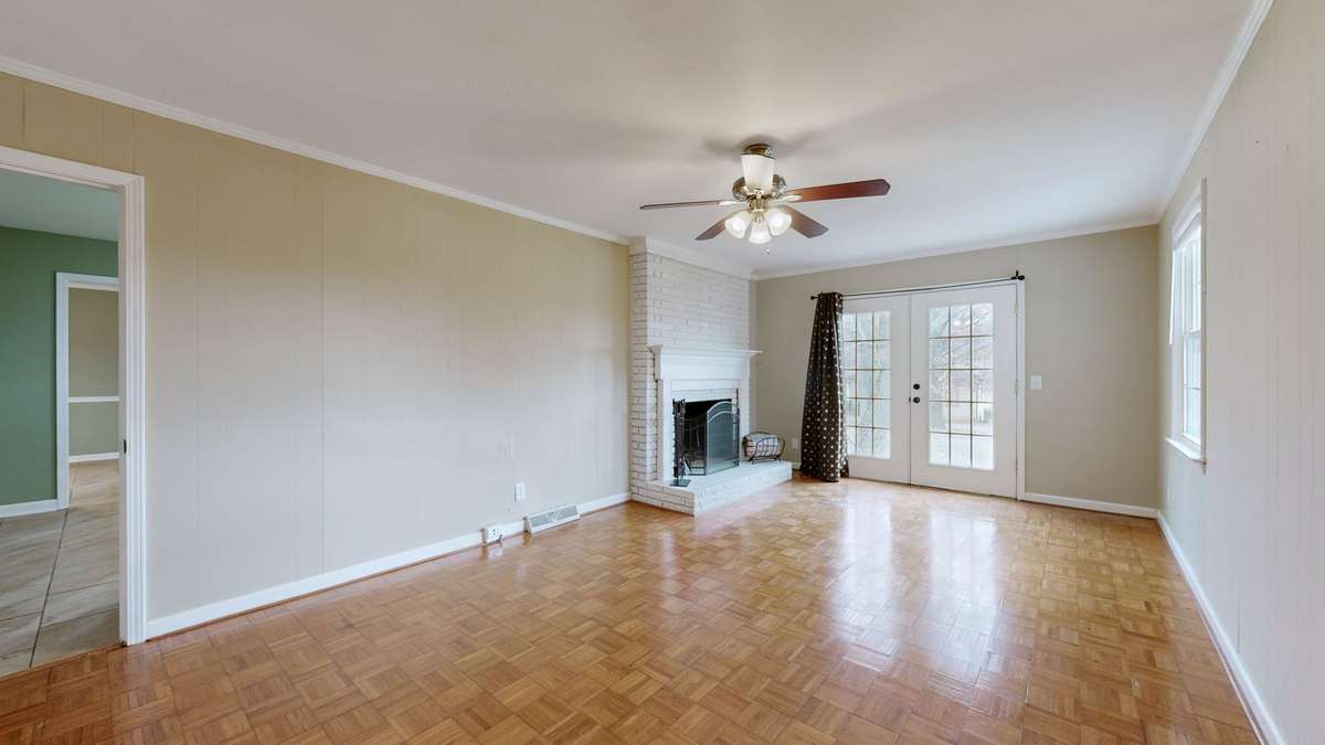 den with fireplace and parquet flooring