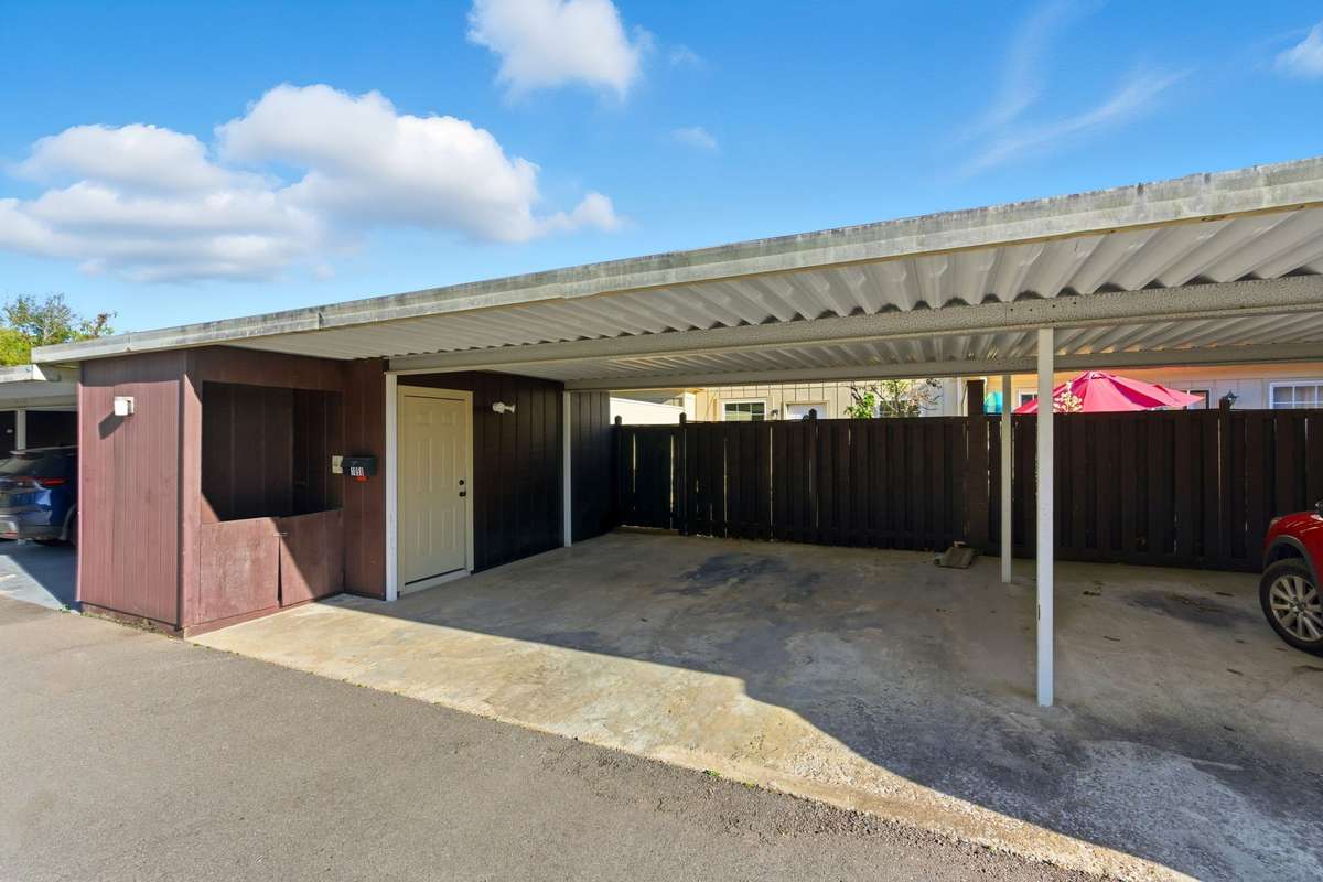 Carport in the back of the condo with storage.