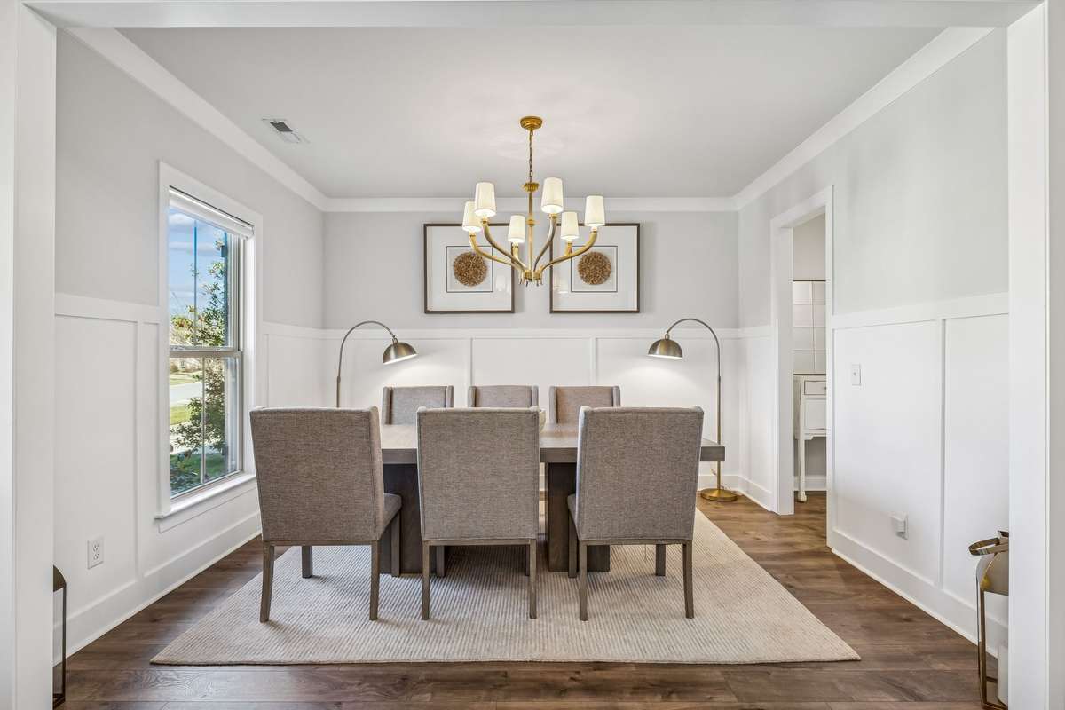 Formal dining room features wainscotting, warm wood flooring, and beautiful lighting fixture! 606 Rumsford Lane, Mt Juliet, TN 37122