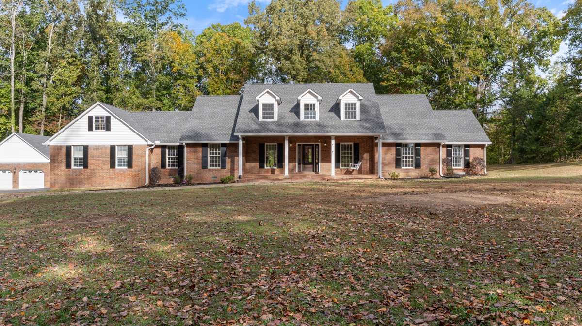Nestled on  a creekside and wooded approx. 5.4 Acres. Offers a brick two car garage/workshop.