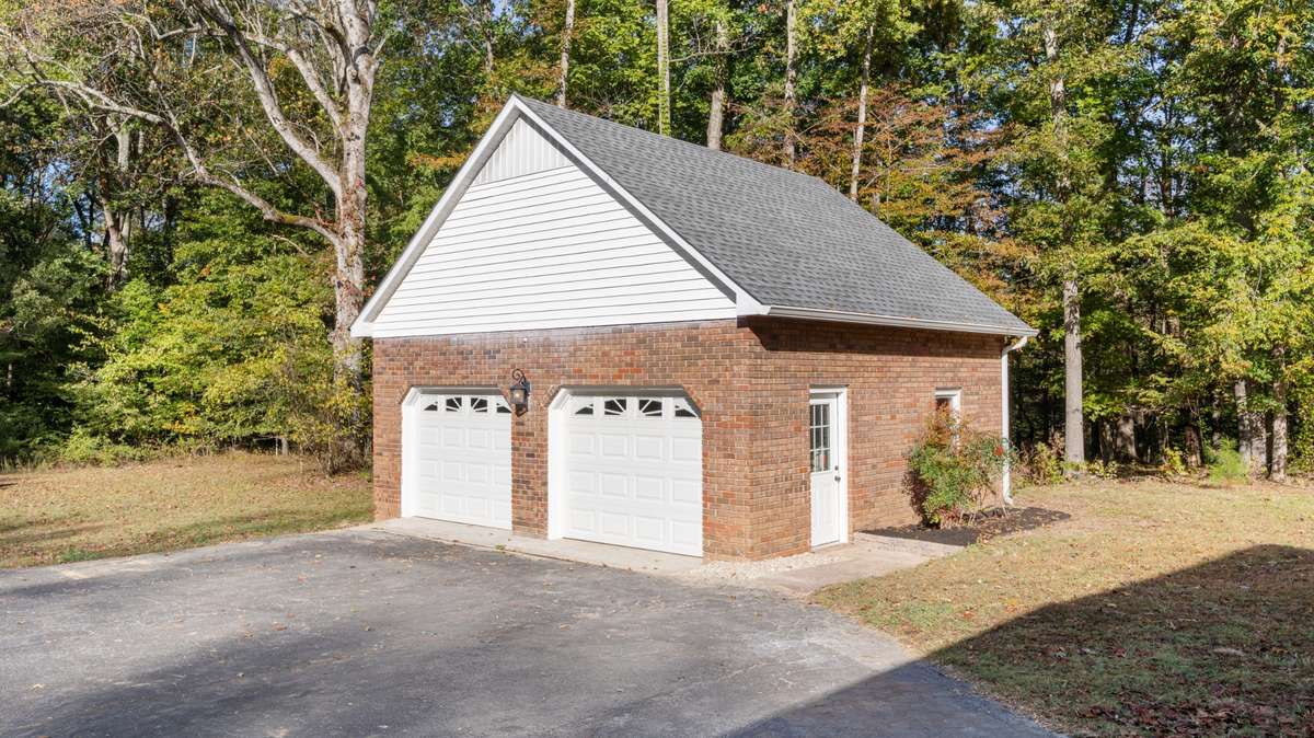 Detached two car garage provides storage for additional vehicles, boat, mowers or for a workshop.