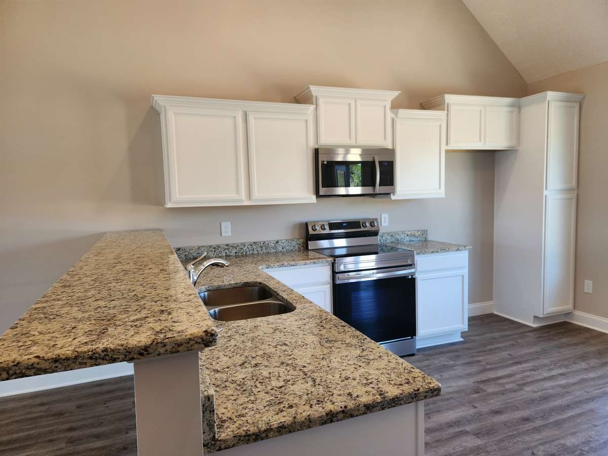 Kitchen has White or Brown Stacked Cabinets and Granite Counter Tops. 
Picture of Previous House.