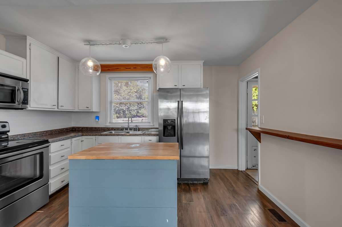 The pop of color on the island makes a statement against the bright white cabinets.