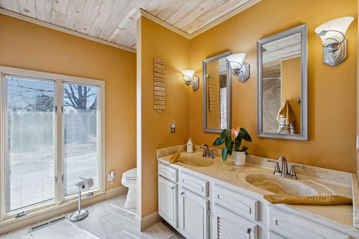 Roomy guest bathroom with double vanity lit by sconces, tiled floor and shower! 1372 Short Mountain Rd, McMinnville, TN 37110