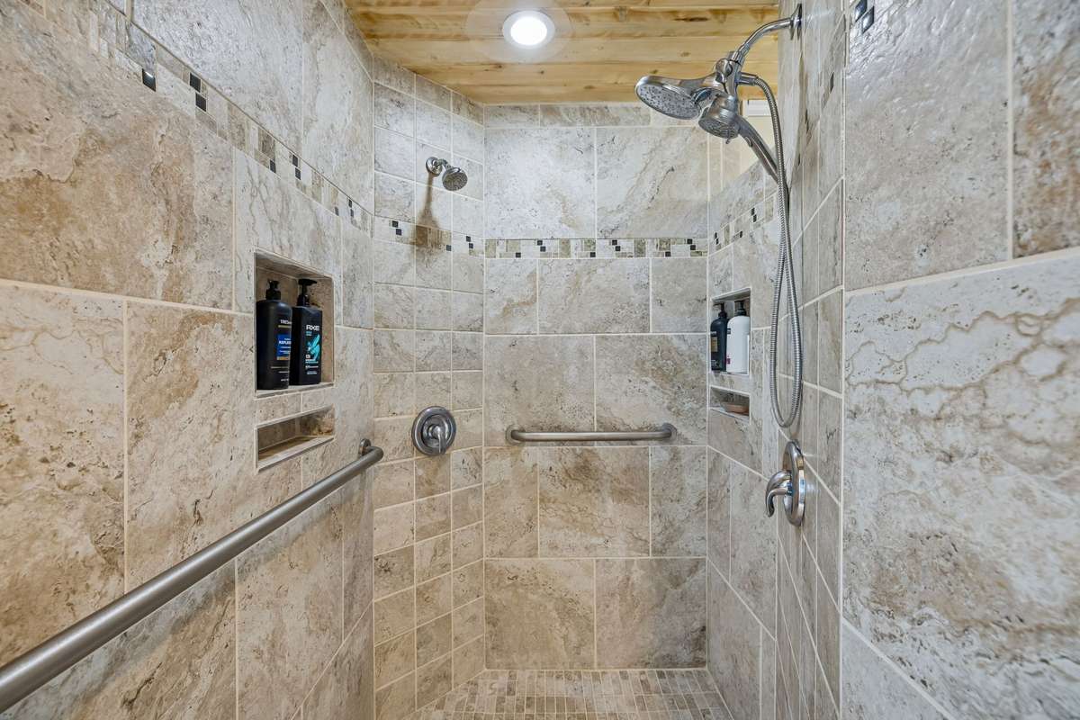 Generous walk-in shower with floor to ceiling tile, multiple shower heads, and thoughtful storage niches! 1372 Short Mountain Rd, McMinnville, TN 37110