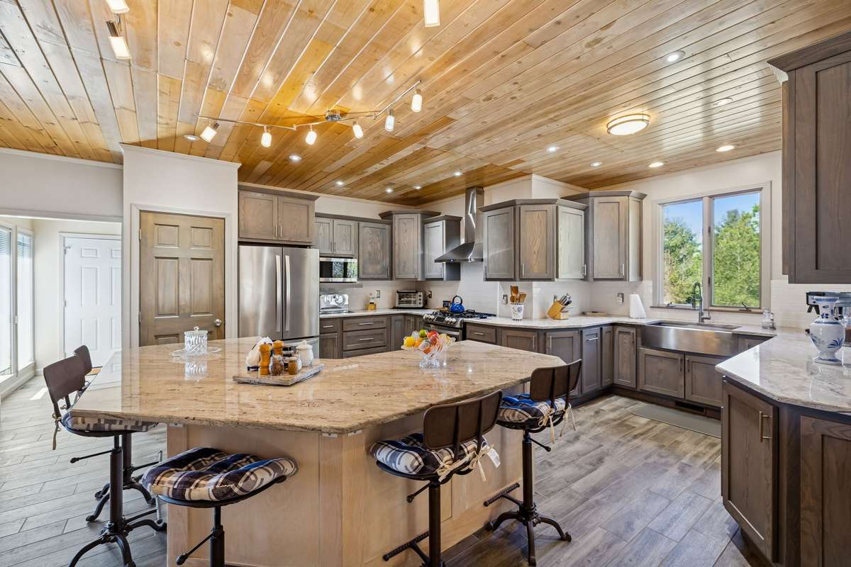 Chef’s kitchen offers an expanse of granite countertops, stainless steel appliances, farmhouse sink, and plenty of space for gathering around the island! 1372 Short Mountain Rd, McMinnville, TN 37110