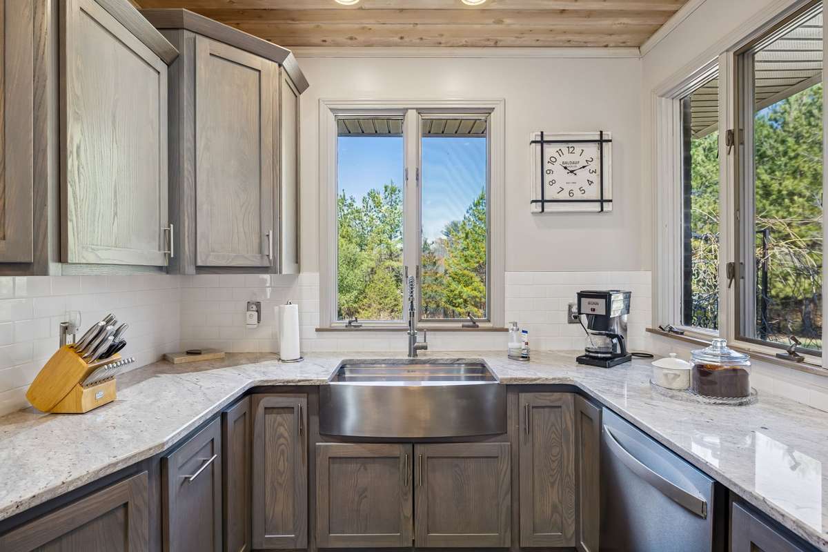 So many standout features in this kitchen including the timeless tiled backsplash, new, modern windows, and this stainless bibbed farm sink! 1372 Short Mountain Rd, McMinnville, TN 37110