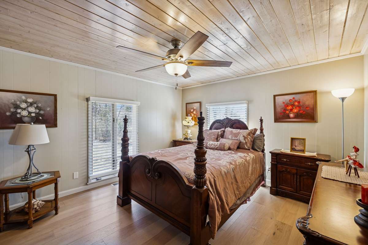 Bright guest bedroom with relaxing views of the surrounding property features tongue and grove ceiling with fan, wide plank tiles, and ample closet space! 1372 Short Mountain Rd, McMinnville, TN 37110