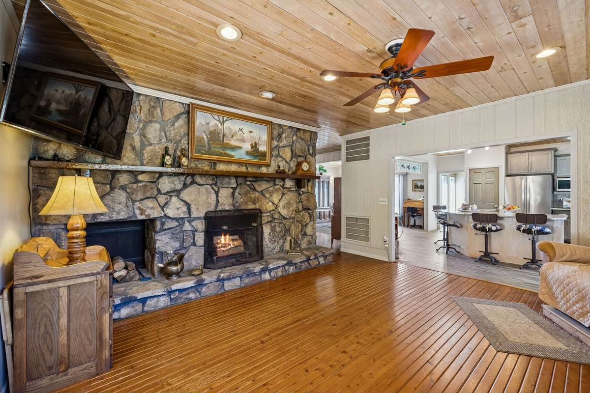 Comfortable family room anchored by an impressive, wood-burning stone fireplace and beautiful wood floors! 1372 Short Mountain Rd, McMinnville, TN 37110