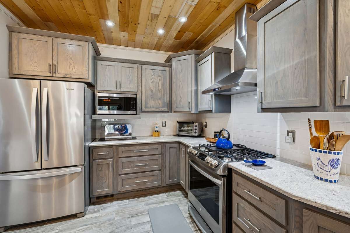 Thoughtfully designed kitchen space features durable tile floor, stainless steel appliances, and gas stove with stainless hood vent! 1372 Short Mountain Rd, McMinnville, TN 37110