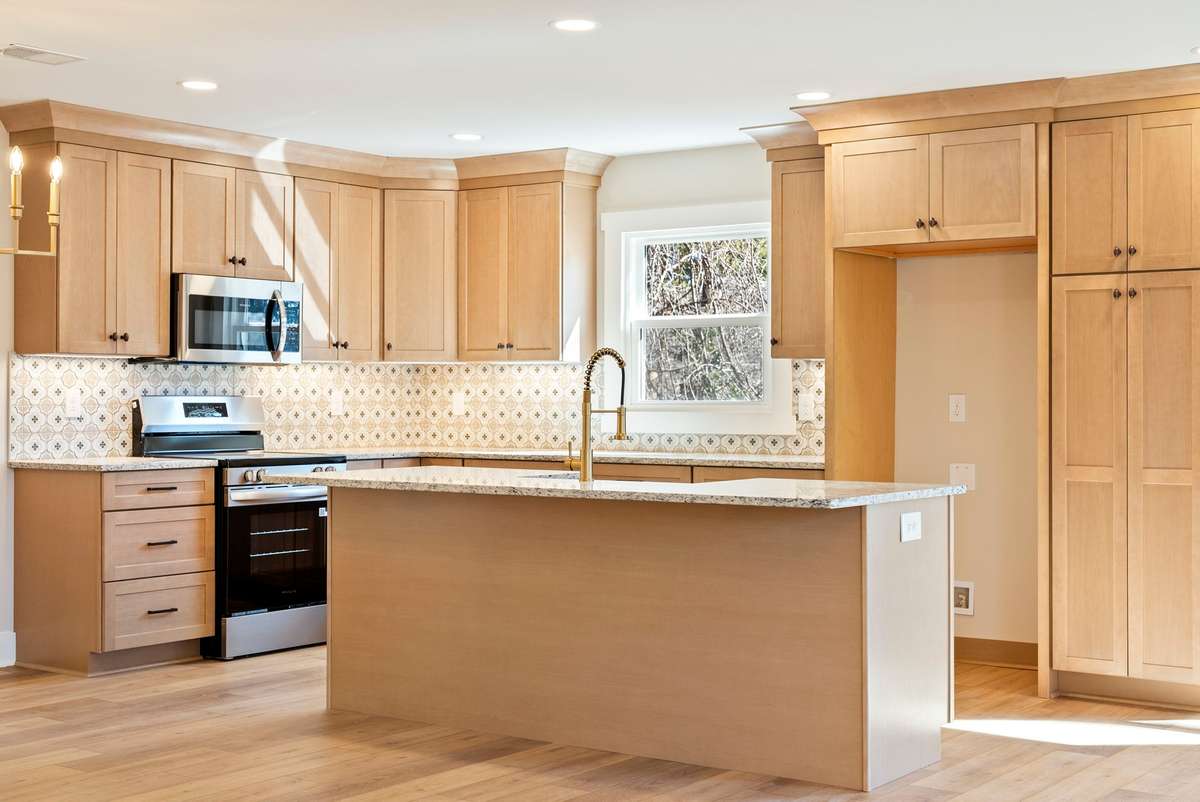 The heart of the home—an open-concept kitchen with expansive island seating, new cabinetry, granite surfaces, updated lighting, and seamless flow into the main living areas! 510 Iris Avenue, Murfreesboro, TN 37128