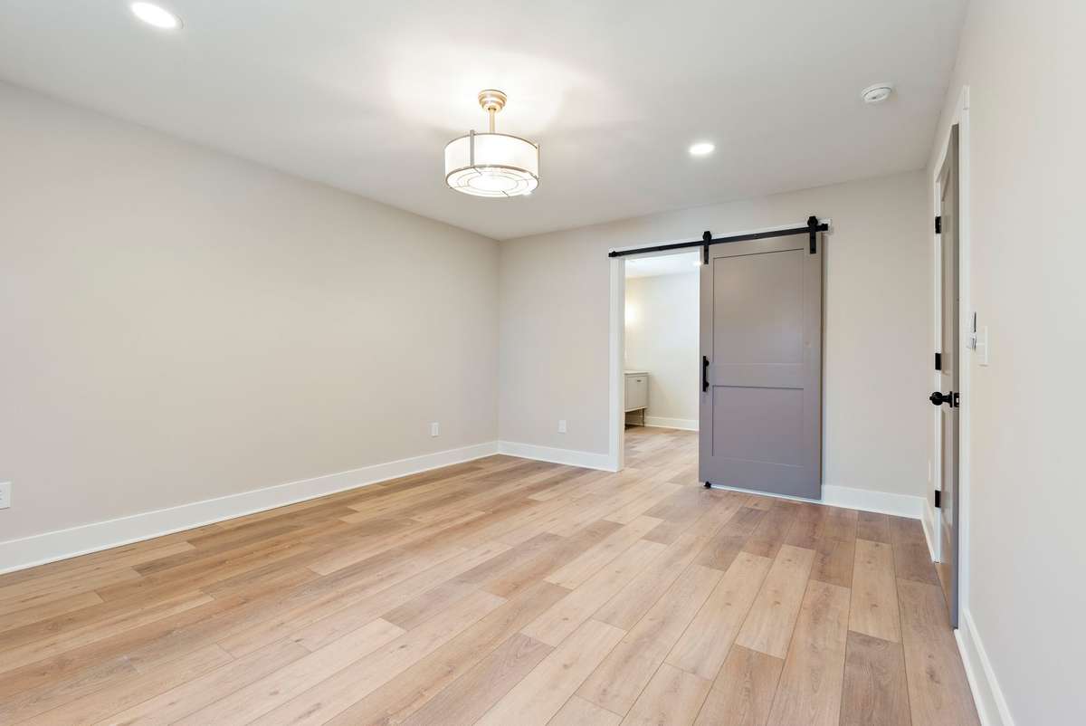 Large primary bedroom with new flooring throughout and a modern barn door entry into the completely redesigned bath!  510 Iris Avenue, Murfreesboro, TN 37128