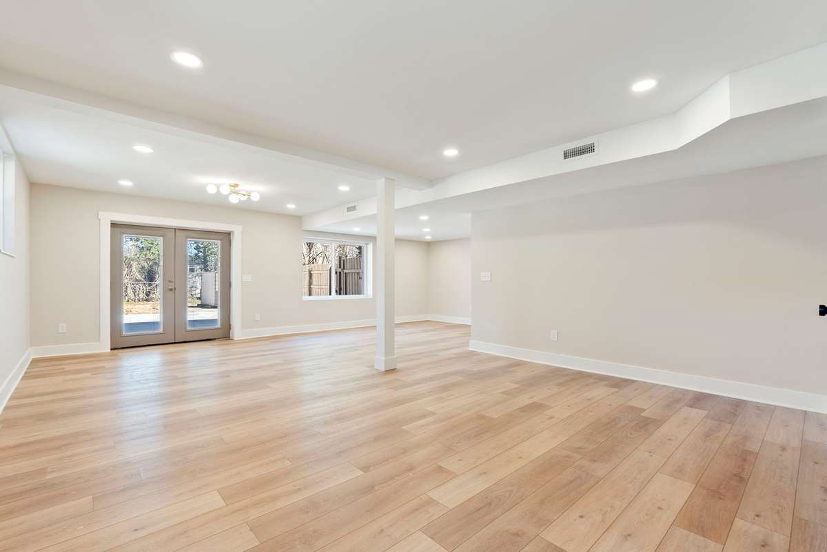 Expansive lower-level living space with recessed lighting and wide-plank flooring—complete with a kitchenette, private laundry, and exterior access, offering ideal flexibility for guests or multigenerational living. 510 Iris Avenue, Murfreesboro, TN