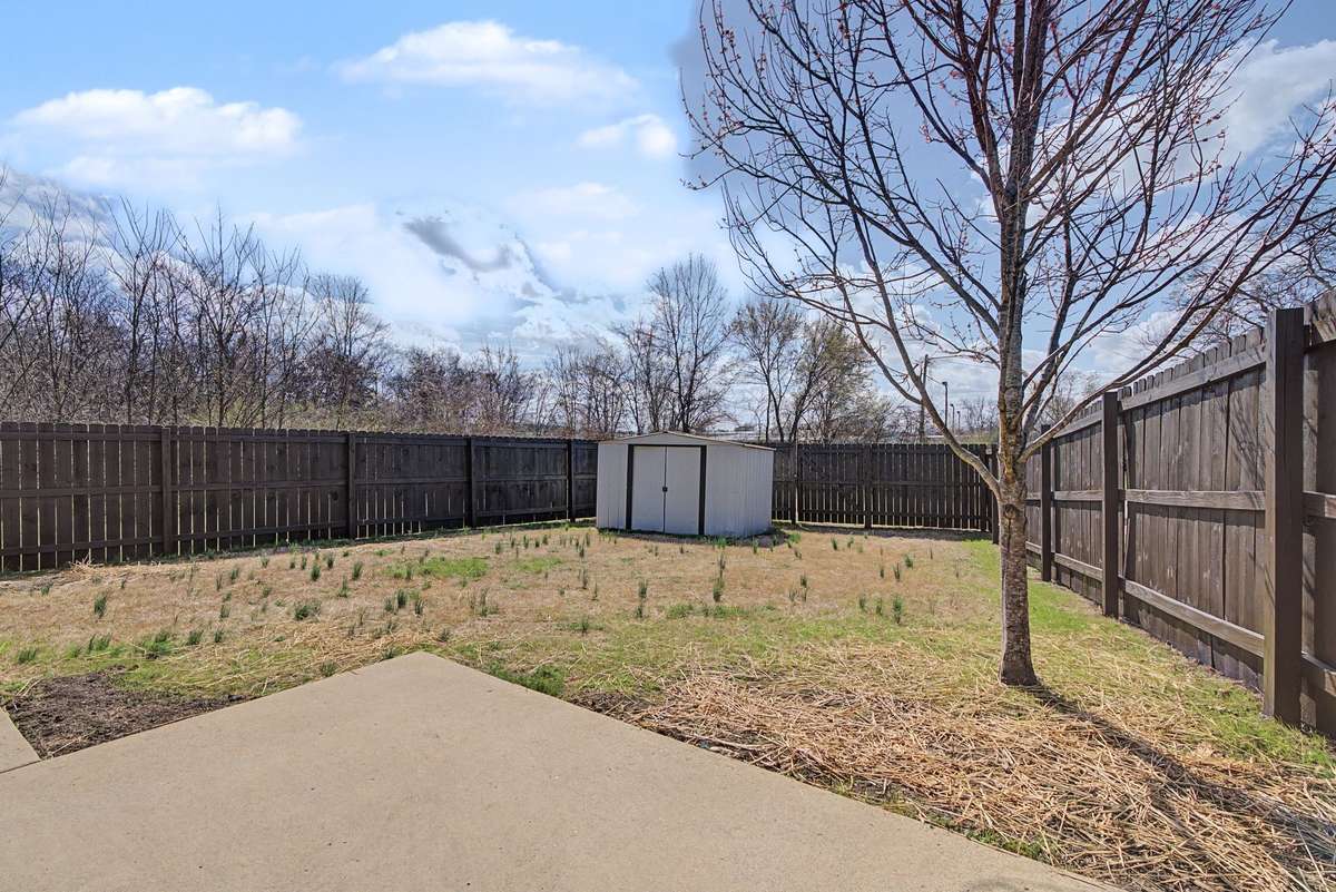 Spacious and fenced backyard with shed included