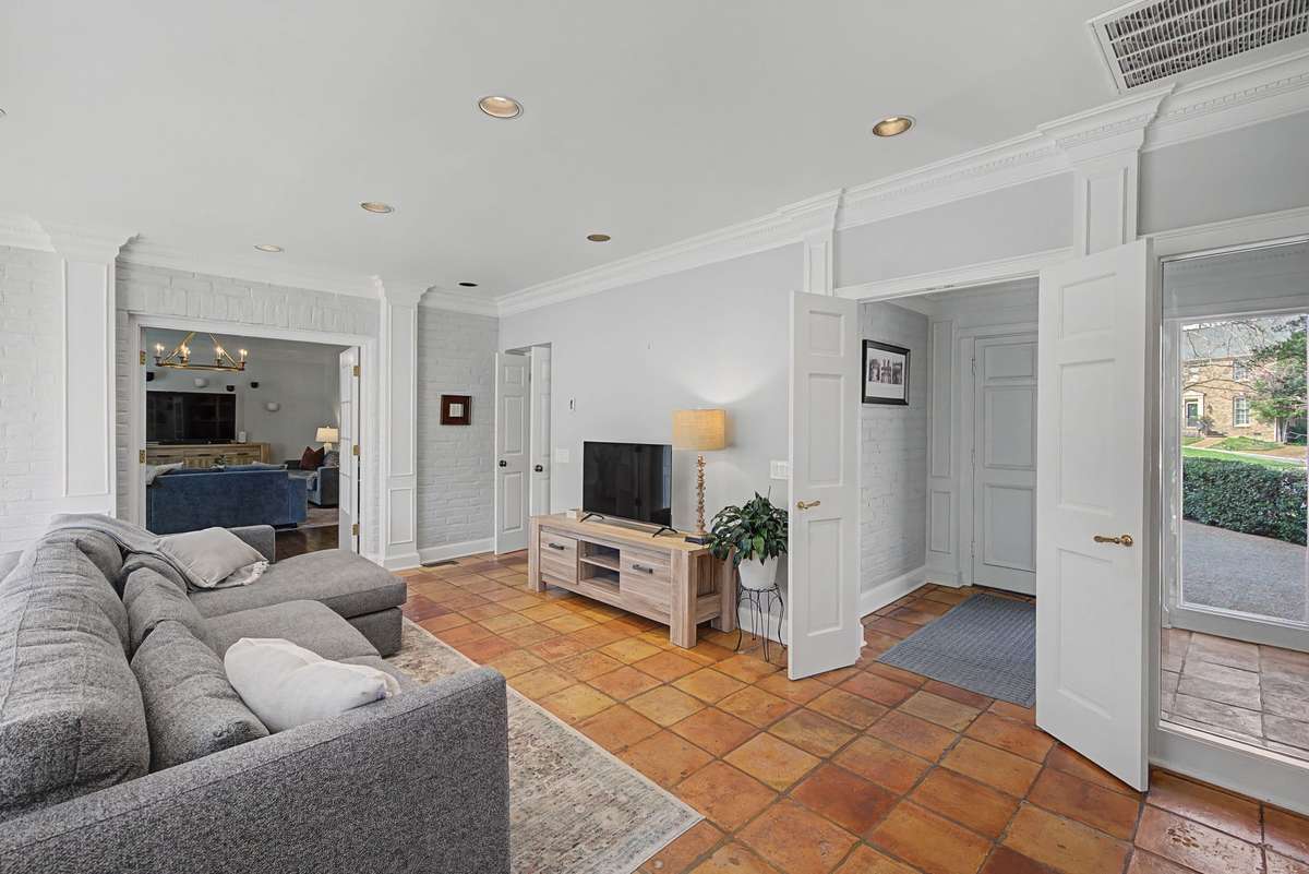 Recreation room with access to front hall, den, and garage side entry.
