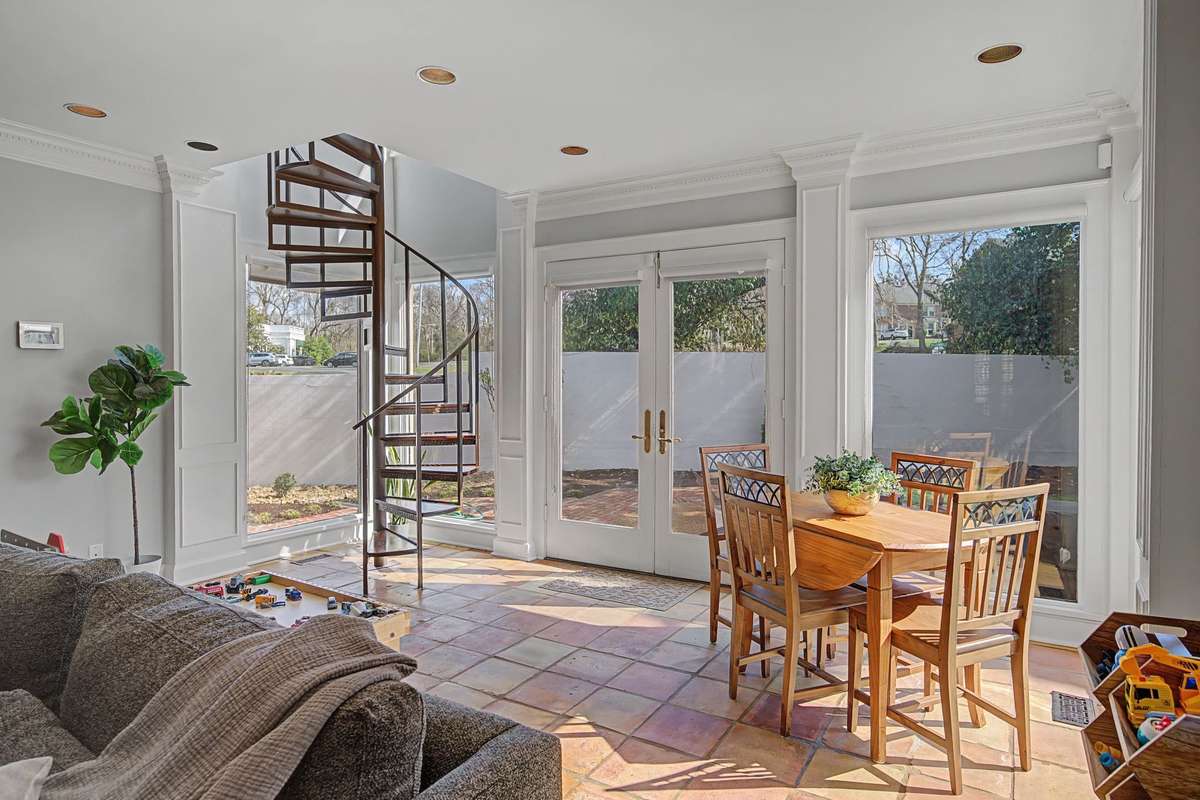 Glass wall of windows with access to backyard.