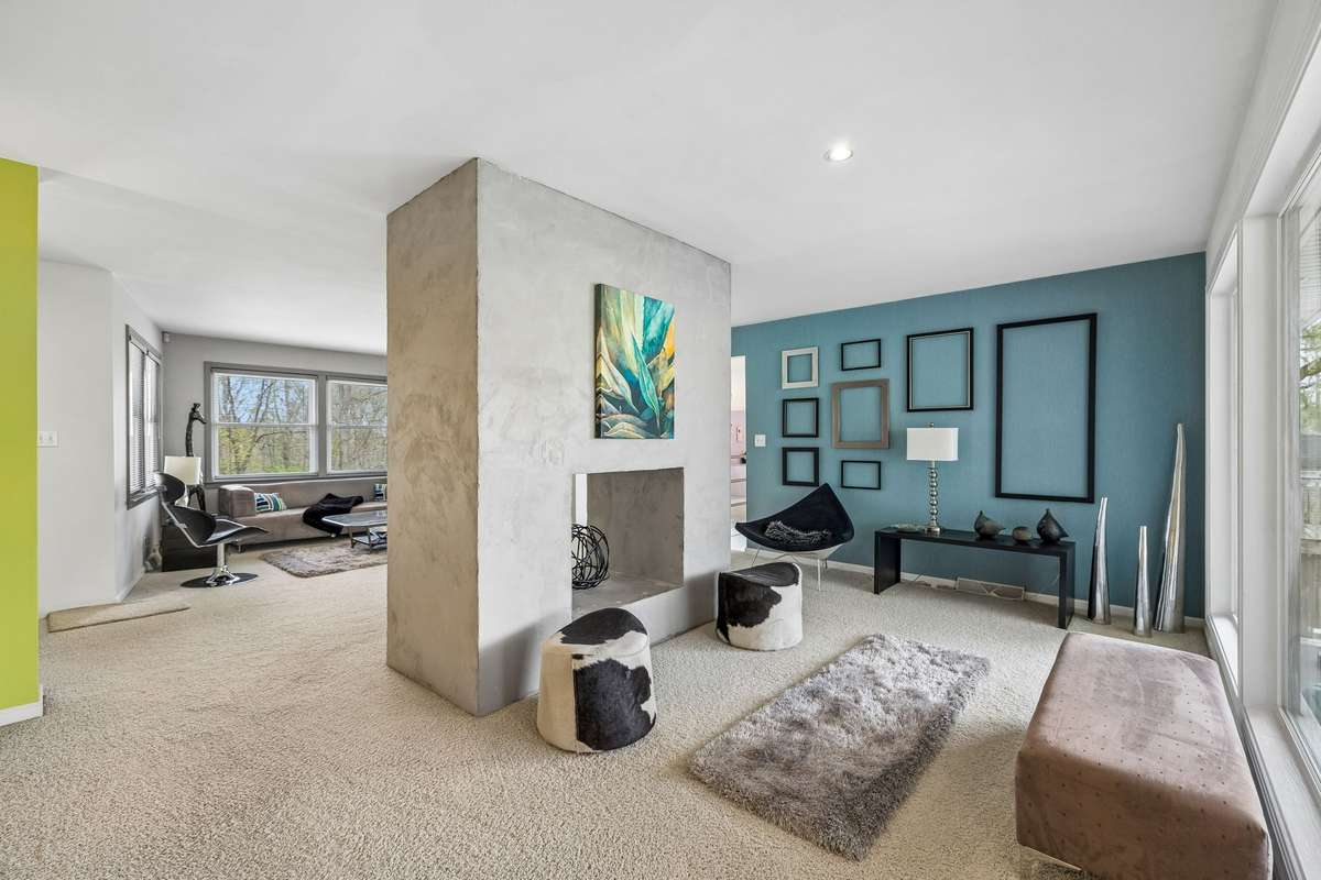 See thru fireplace from living room to additional sitting area looking onto the covered patio and back deck
