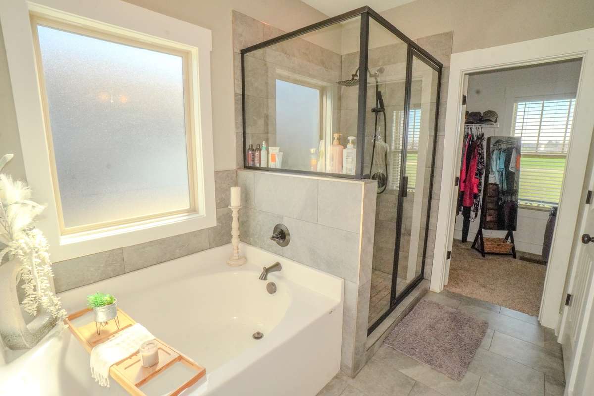 Tile flooring and a separate shower and tub is in the primary suite