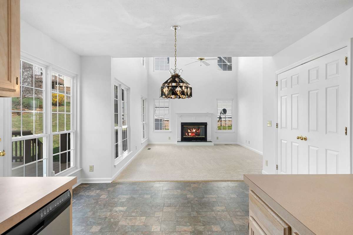 Open kitchen to two story family room with fireplace and lots of windows