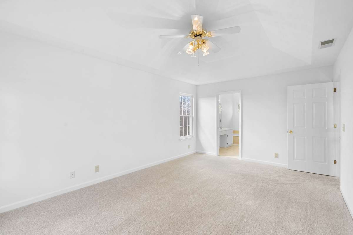 Spacious primary bedroom with trey ceiling, ceiling fan and full bath with whirlpool tub, separate shower, double vanity, and walk-in closet