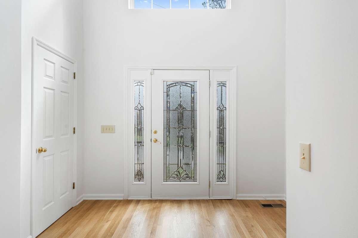 Two story entry foyer with refinished hardwood floor, coat closet and power room