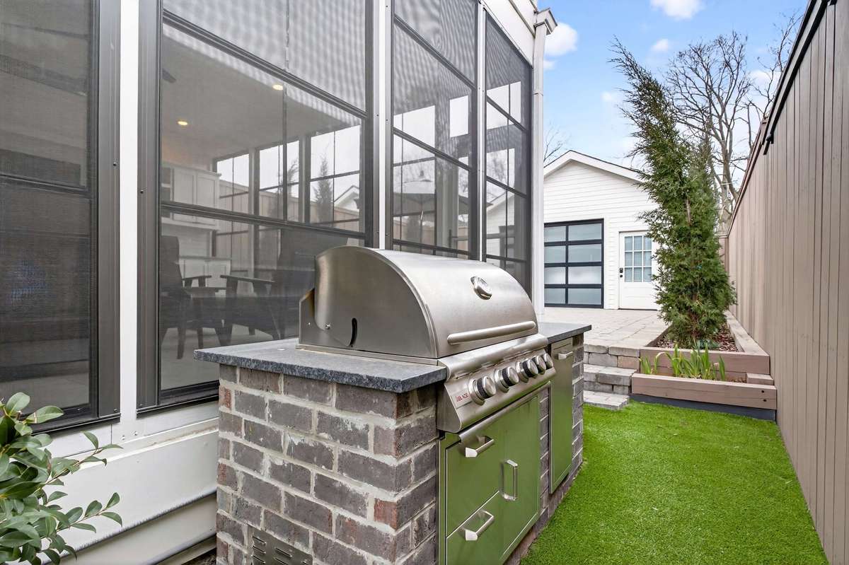 The outdoor space features a custom upgraded gas grill and turf, creating an ideal setup for both entertaining and pets.