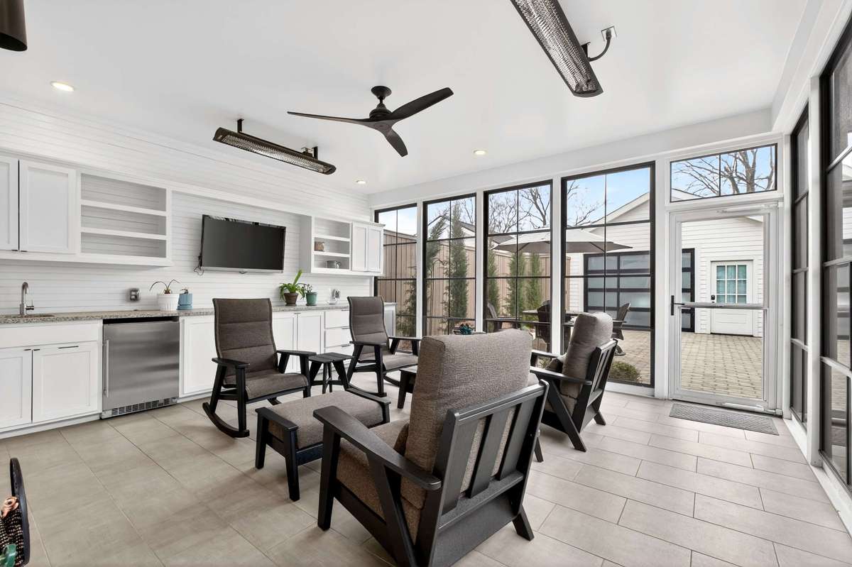 The outdoor area features beautiful custom millwork with a sink, beverage center, and outdoor TV, plus plenty of space for multiple seating and/or dining area