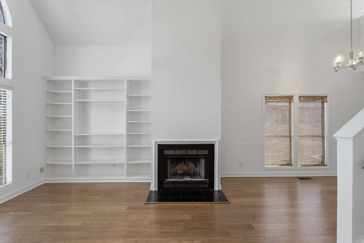 Spacious living room with vaulted ceiling, fireplace, and custom built ins