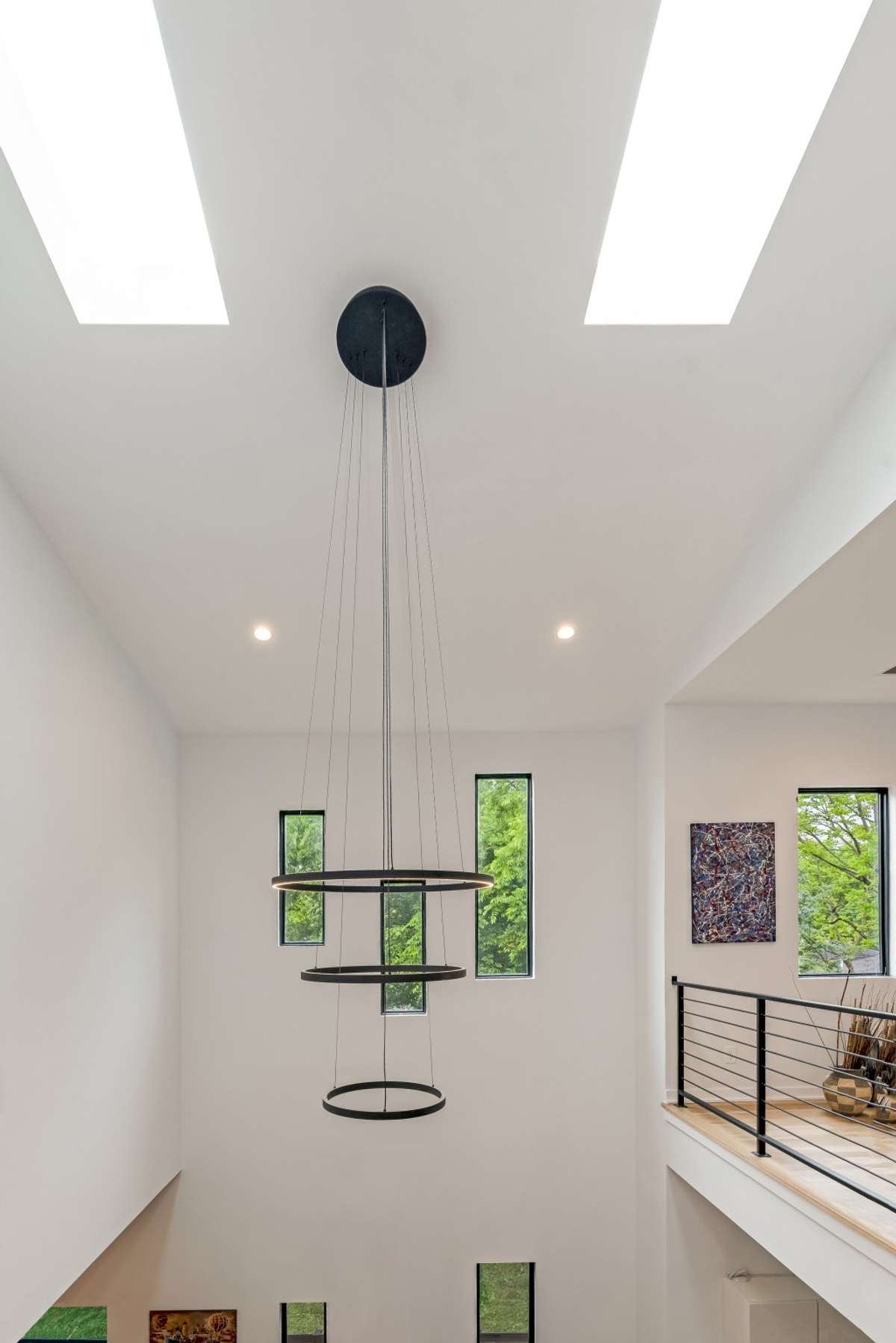 Another designer chandelier adds an artistic flair to the dining room, combining elegance with modern design on both floor levels