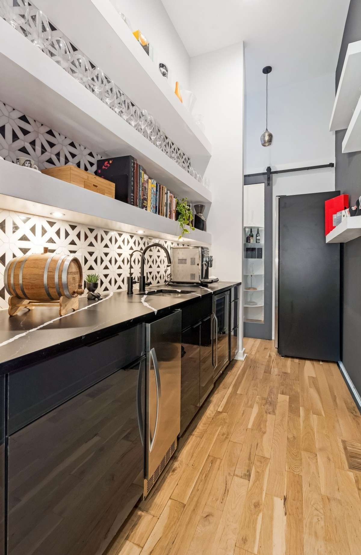 The Scullery features a wine room, wet bar with ice maker, a beverage refrigerator, and coffee bar
