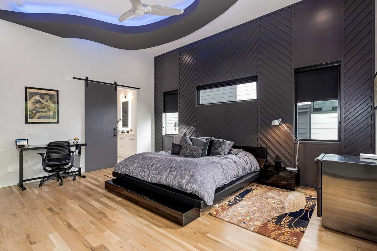 This well-appointed space is further elevated by an expressive wood-paneled accent wall and a charming barn door that leads into the primary bath.