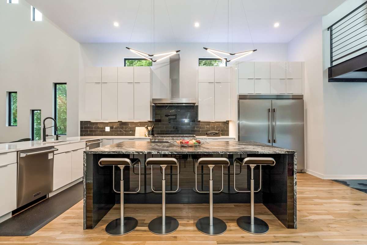 Equipped with a premium appliance package, including a Miele 8-burner gas range with double ovens, two Viking dishwashers, a built-in m/w, and a Frigidaire Professional Series refrigerator, this kitchen is designed for both performance and luxury