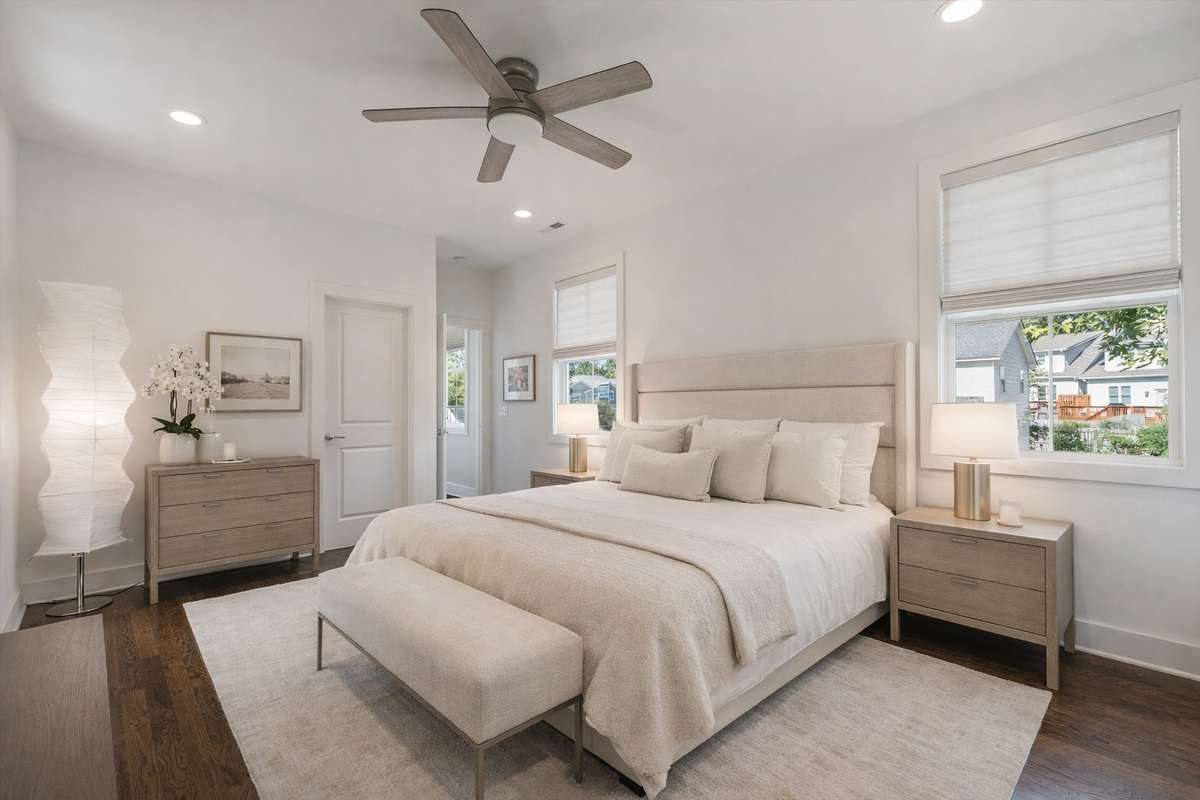 Primary bedroom located upstairs overlooking the backyard. The primary bedroom features two walk-in closets, a large bathroom, beautiful hardwood floors, and large windows with custom blinds. ( Virtually staged)