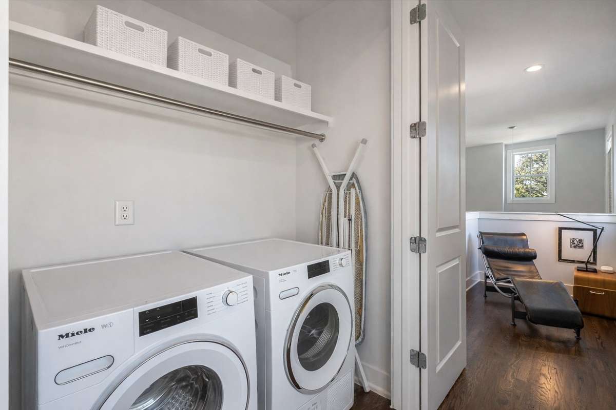 The laundry room is located on the second floor and features a Miel washer and dryer which come with the property. Just beyond the laundry is a landing area and the perfect reading area.