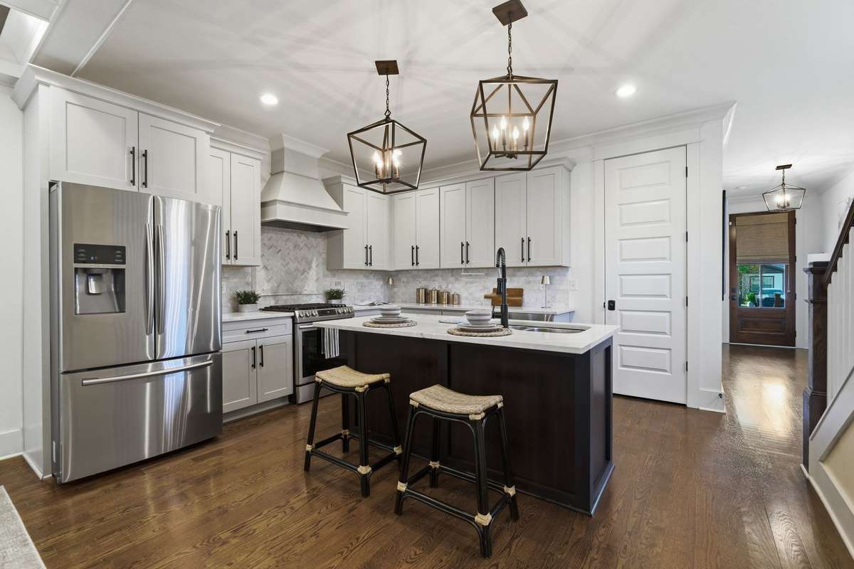Kitchen with large island, stainless steel appliances, pantry, and bar seating.