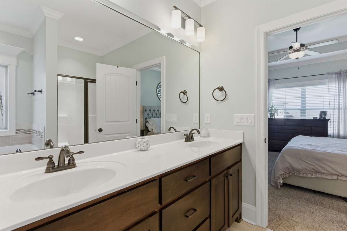 The primary bath has a large double sink vanity with lots of drawers and storage.