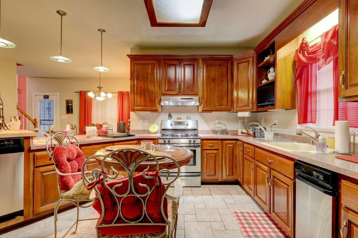 Kitchen includes stainless steel gas stove, gas indoor grill, 2 sinks, trash compactor, fridge, & dishwasher