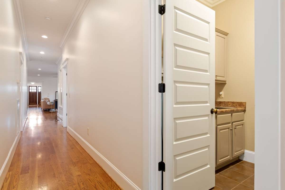 The laundry room has laundry sink and extra cabinets for storage...