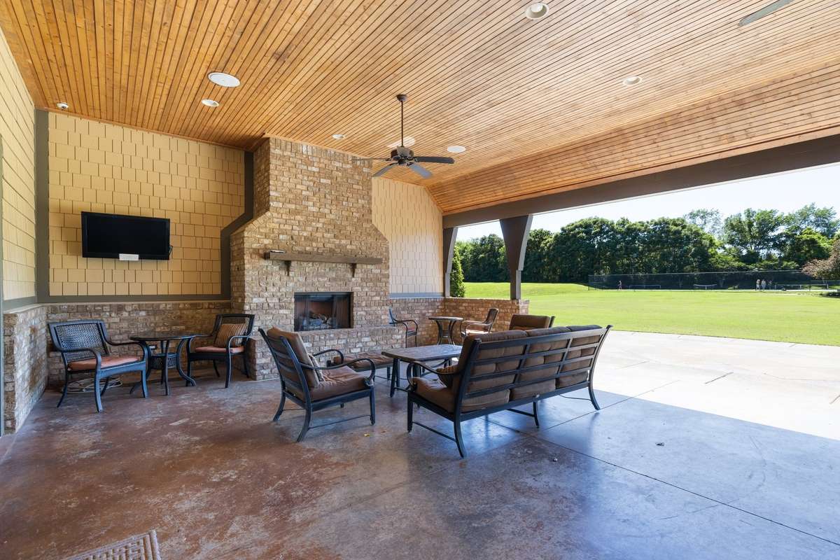 Huge covered porch area with seating and outdoor dining tables...notice the lawn to the right...its used for outdoor concerts and movies in the neighborhood...