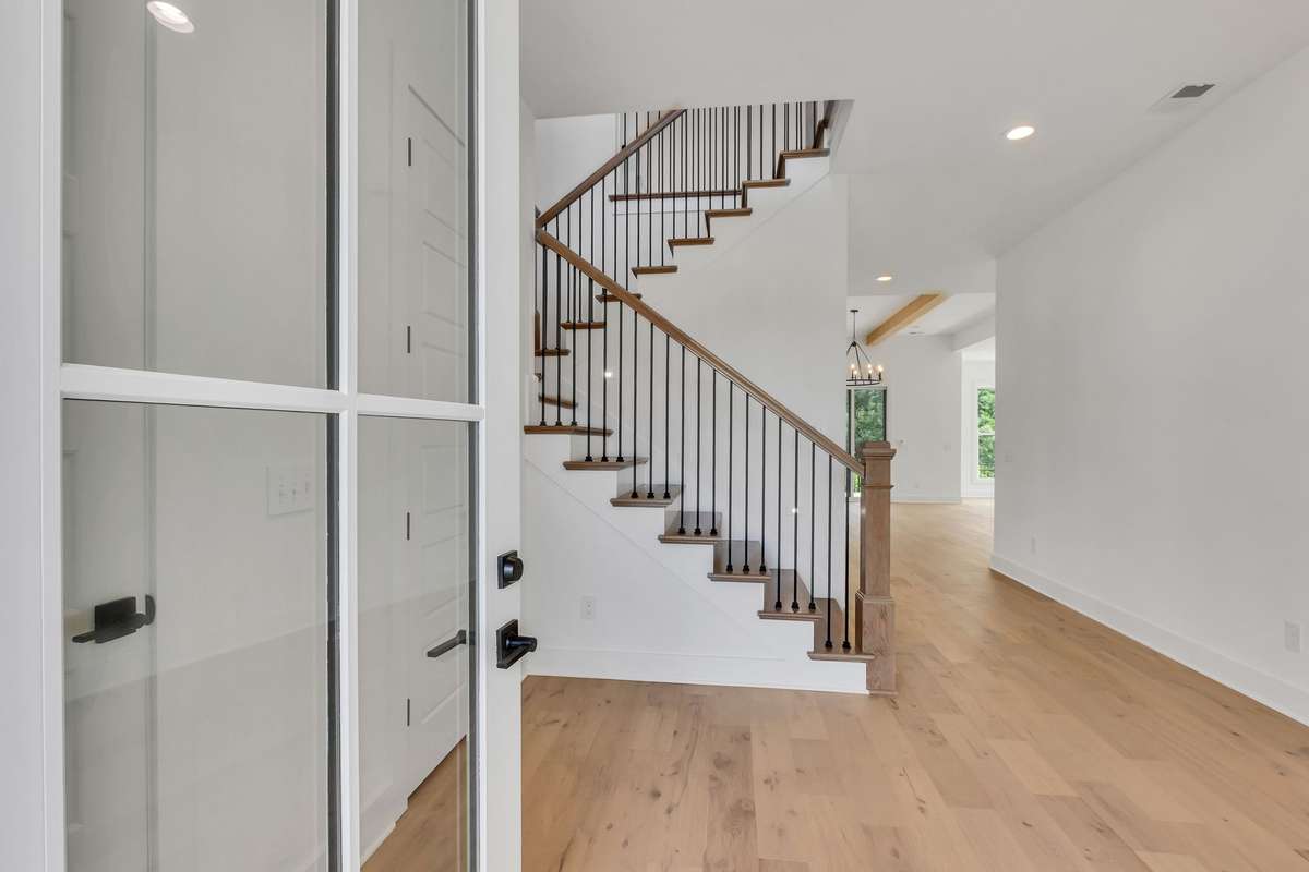 Photo of a previous built Ensley home in another community. Shown for illustration purposes only. Colors and materials will vary. Step into this beautiful home and be greeted with the open staircase featuring white oak wood treads and metal spindles.
