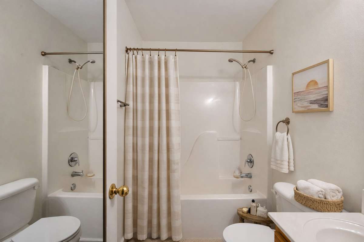 The hallway full bathroom with a shower/tub combo serves both secondary bedrooms.
