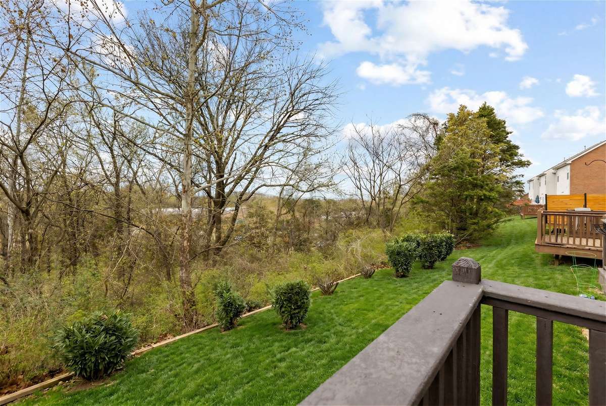 Back deck overlooks treetops and greenspace.
