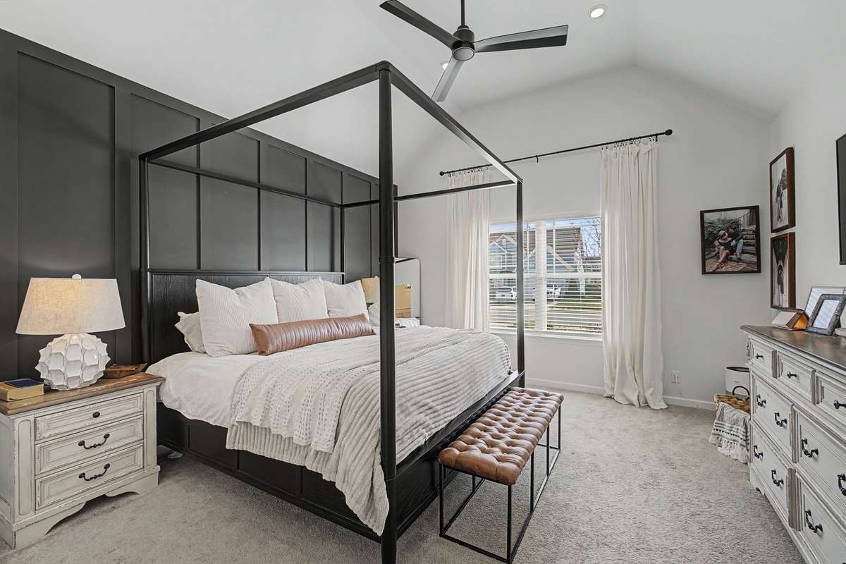 Spacious Primary Suite with Accent wall of Wainscoting, Vaulted Ceiling, Ceiling Fan, Walk In Closet and Full Bath