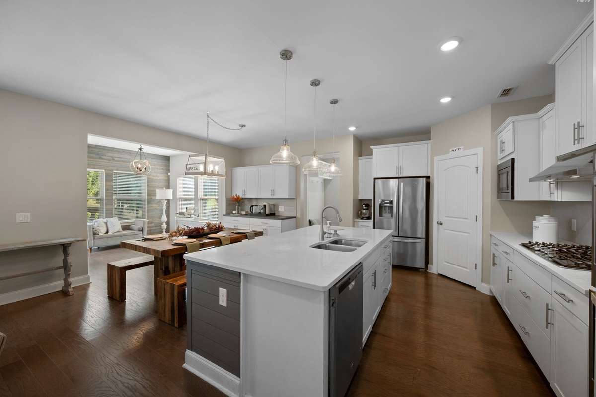The kitchen, island seating, and dining area together provide ample seating for everyday living and entertaining.
