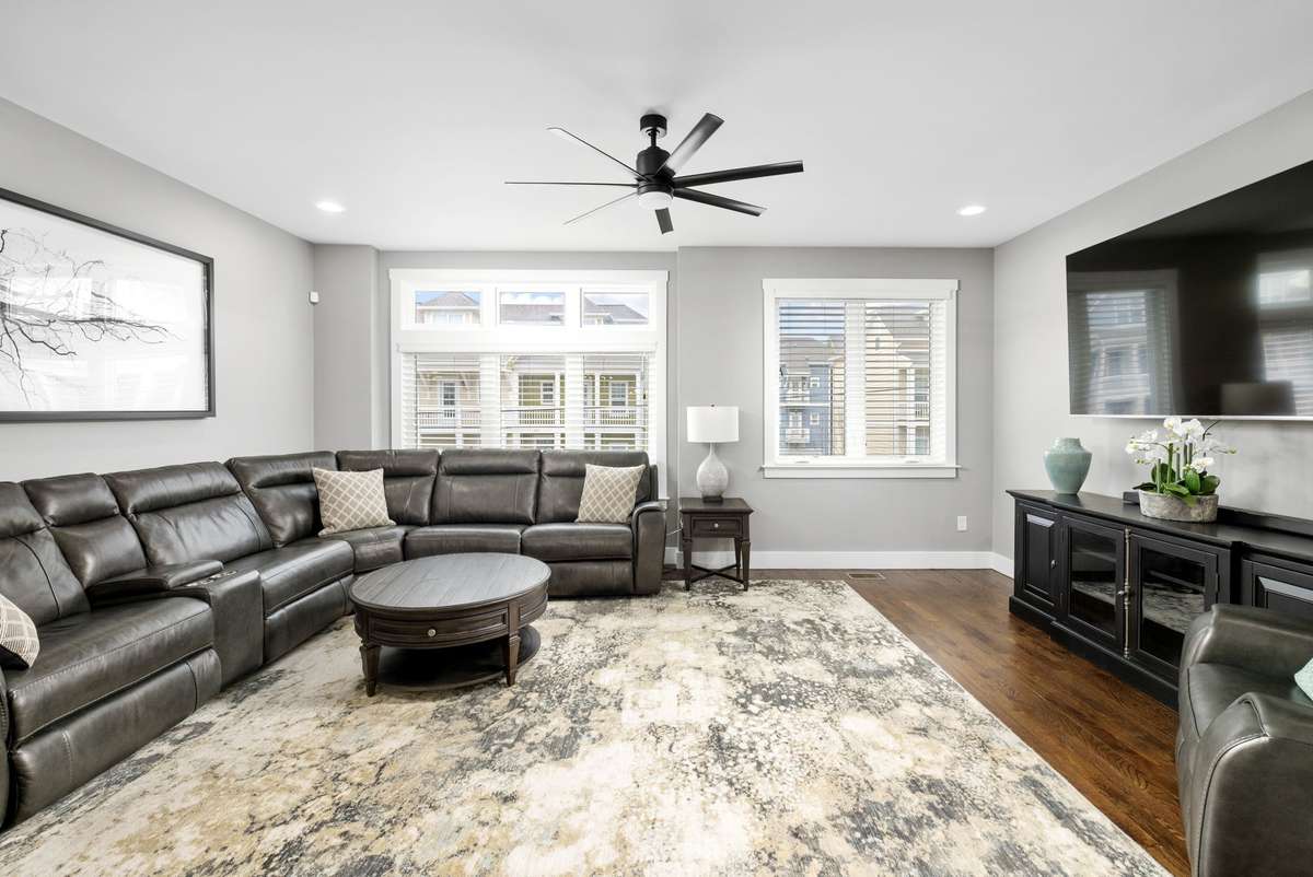 Spacious living area with large windows, modern finishes, and comfortable furnishings that create a welcoming space to relax. Furniture is included, making this home move-in ready and perfect for effortless living.